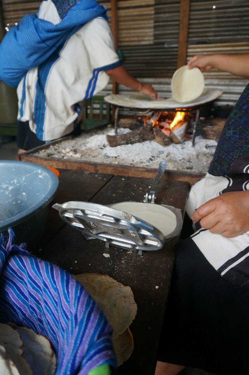 Fig. 4 : Les belles-sœurs de Valentina font des tortillas à la main, à partir de farine Maseca et avec une cuisson au feu de bois, de manière simultanée avec la garde des enfants, 2021. Photo de Morgan Jenatton